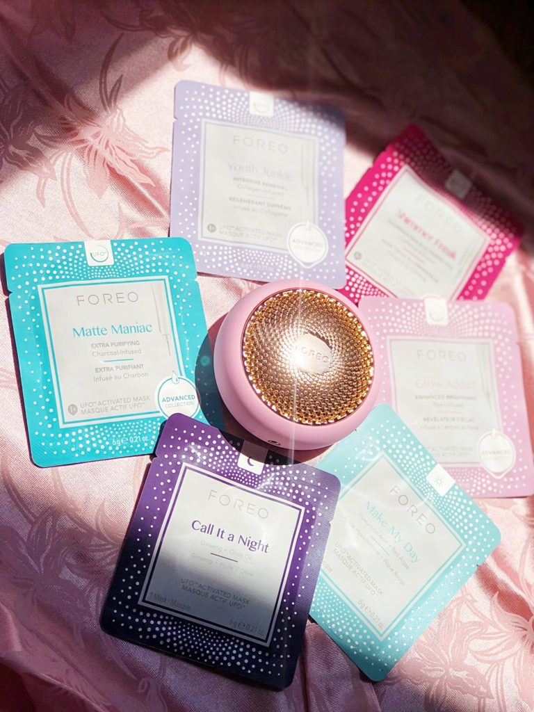 Foreo UFO with face masks on a pink background.