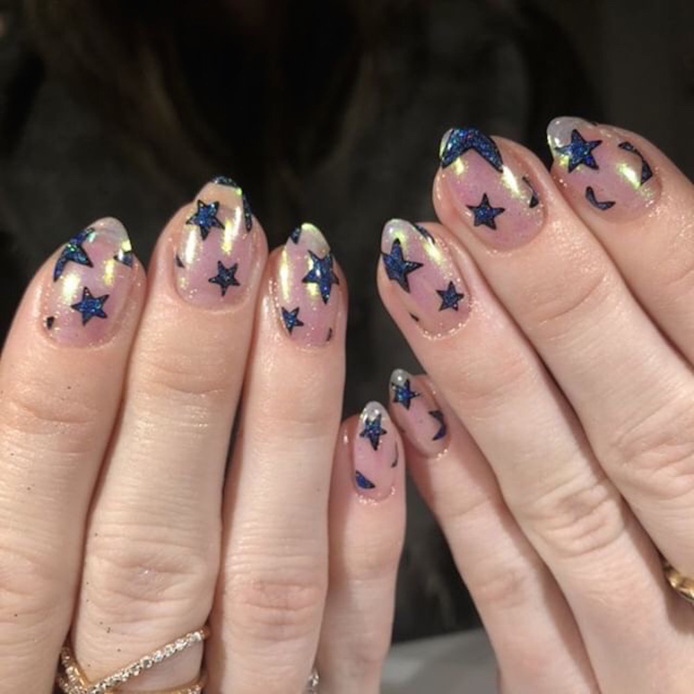 Nail art with blue star designs by Penny Nail on a black background at the Leafgel seminar.