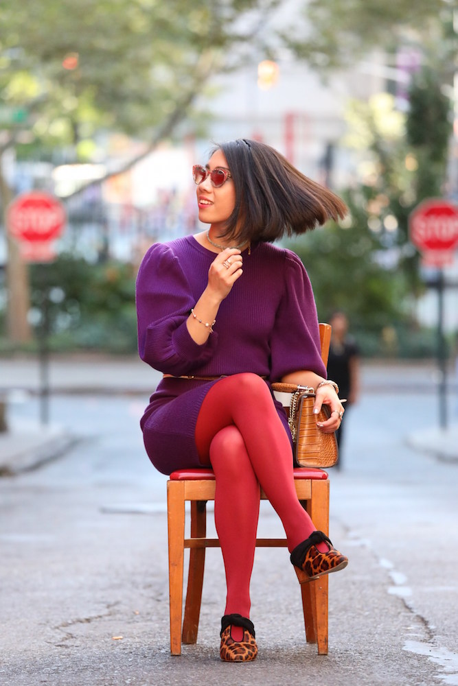Red tights, a purple dress, and brown bag.