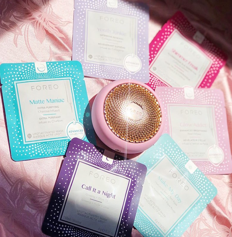 Foreo UFO with face masks on a pink background.