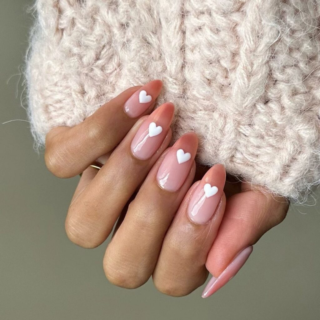 valentine's nails design with a medium pink base and white hearts.