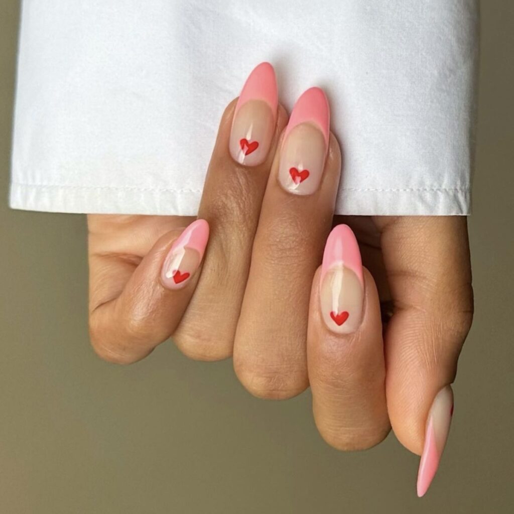 french manicure with pink tips and small red hearts on the bottom of each nail.