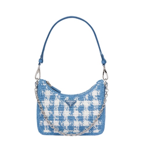 A blue and white Prada houndstooth handbag on a white background.