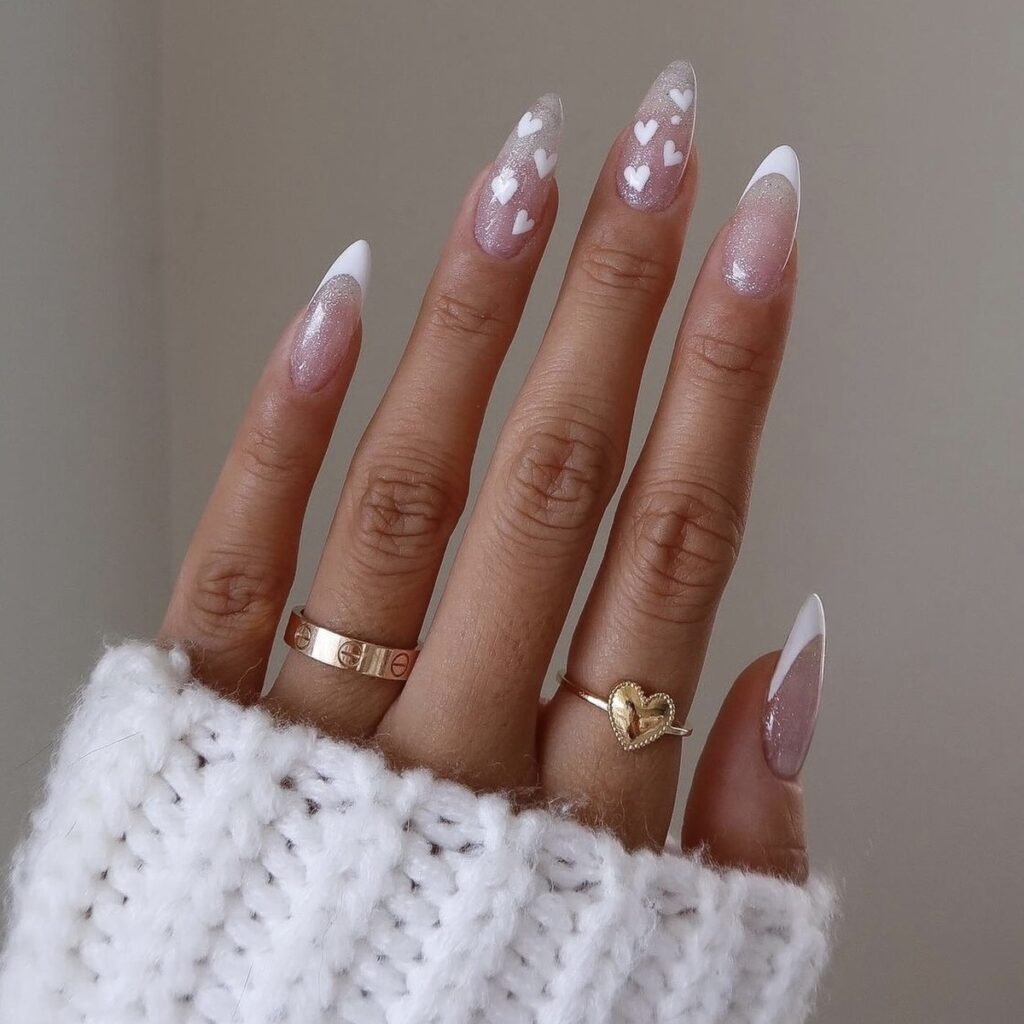 french manicure with white tips and white hearts on the middle and ring fingers.