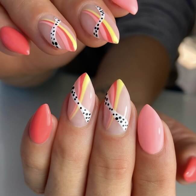 Playful summer nail trends featuring coral and yellow swirl details with polka dots