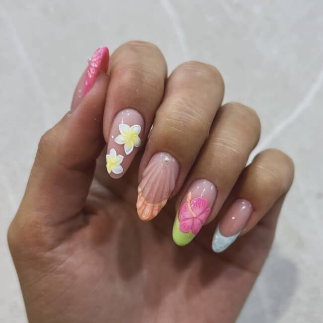 A hand with bright Hawaii manicure with hibiscus flowers and French tips.