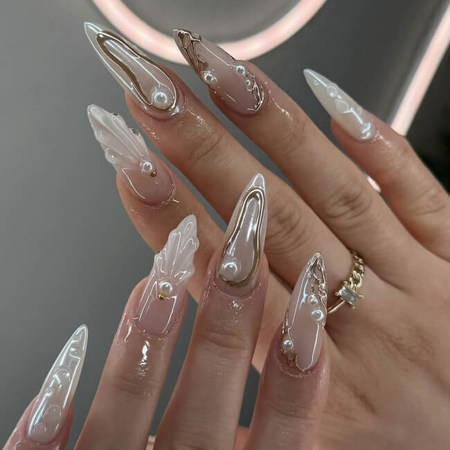 White nail design with pearl and shell details.