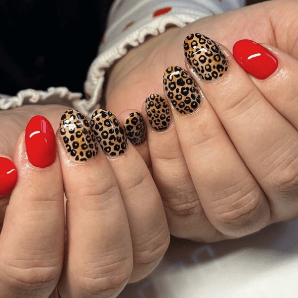 A pair of hands with an animal print manicure, one of the best autumn nail designs 2025