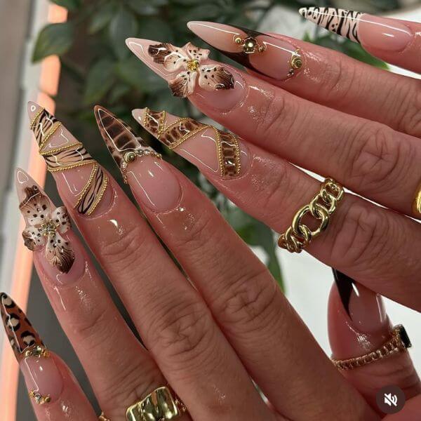 Hands with animal print manicure set and gold rings