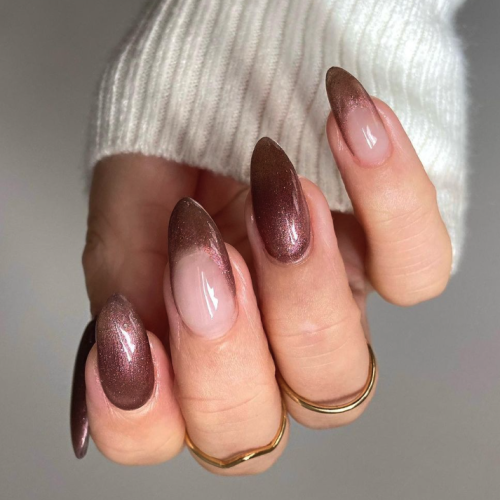 deep pink metallic nails with a white sweater sleeve.