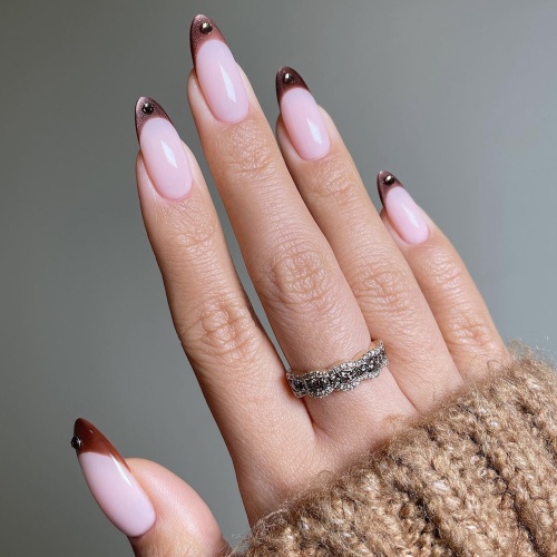 pink french manicure with a rhinestone on each tip.