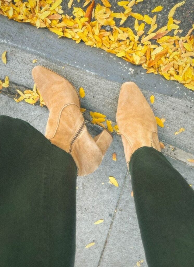 INEZ Boots Paz 70 style with a background of gold leaves on a New York City street
