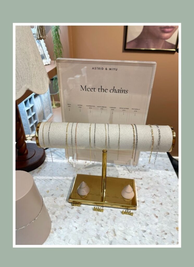 Dainty permanent bracelets on a jewelry holder with a sign that reads Meet the Chains.