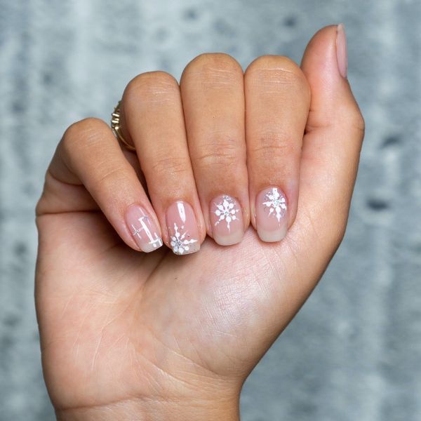 minimal manicure with a snowflake design