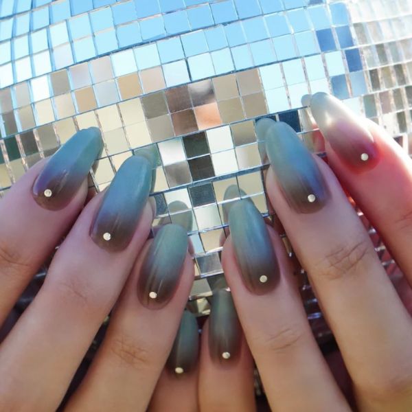 medium blue new year nails 2026 with sparkle embellishments and a disco ball background.