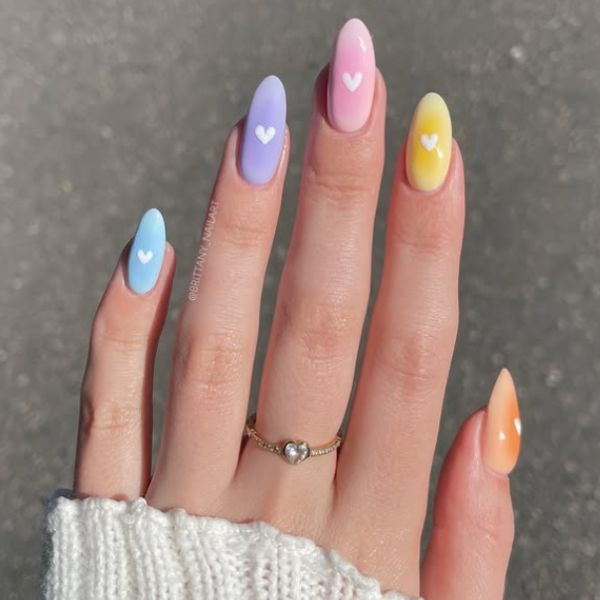 Easter manicure with white hearts on a gray background.