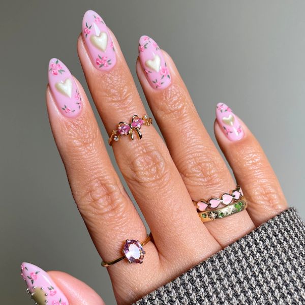 pink easter nails with white hearts on a gray background.