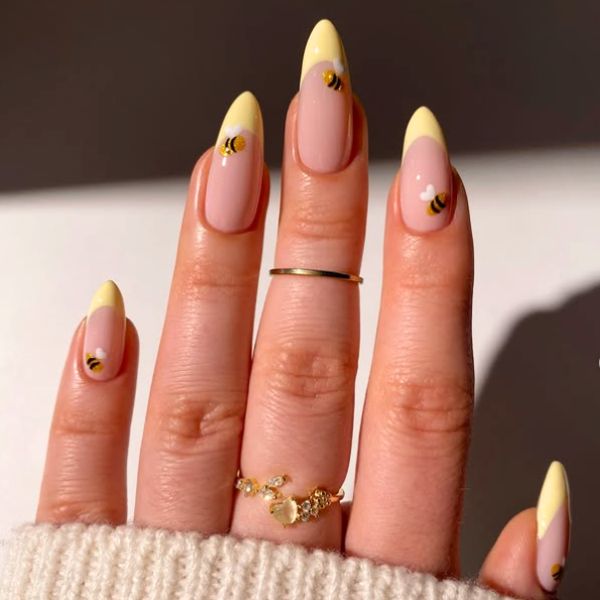 Honey nails with bee design and yellow French tips.