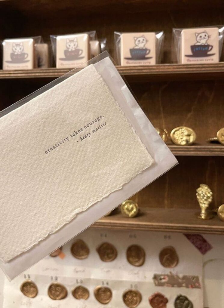 A rustic paper that says "creativity takes courage" used as junk journal supplies.