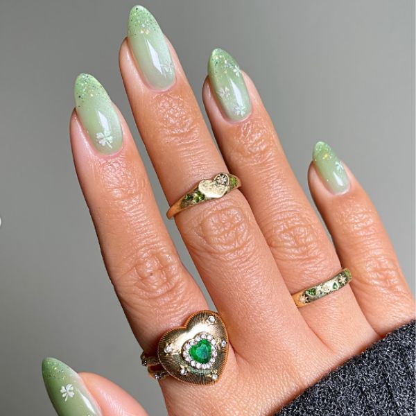 Mint green manicure with a long almond shape with a gray background.