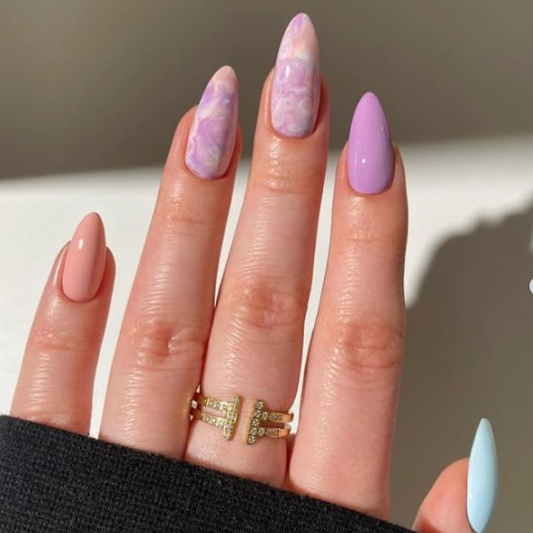 Close up of pastel purple manicure with a beige background.
