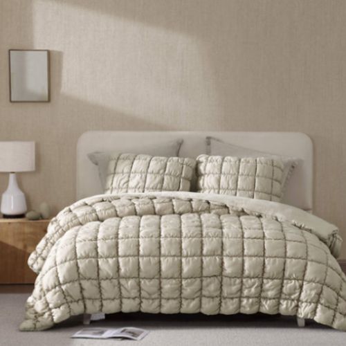 Neutral-toned bedding layered with soft textures in a light beige background.