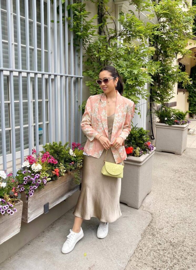 Outfit photo wearing white sneakers during the summer, a floral blazer, and slip dress.