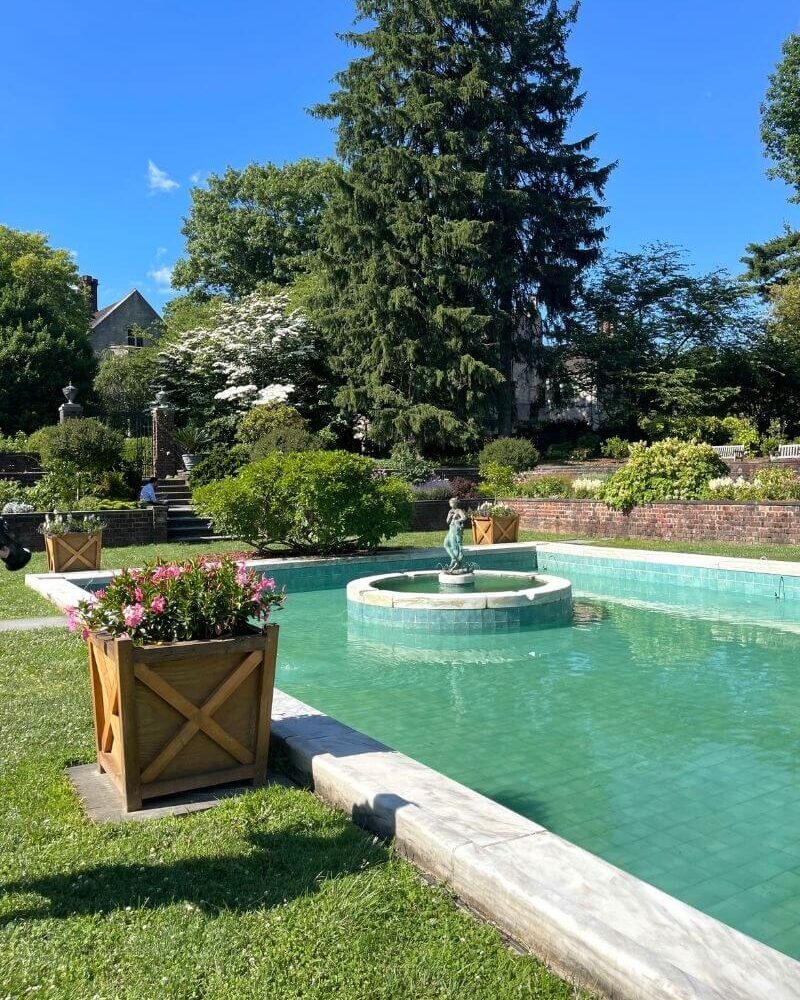 View of a pool and trees at Planting Fields, one of the best Long Island gardens in New York.